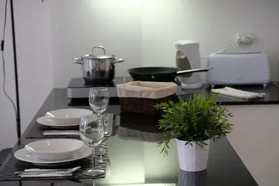 a table with two wine glasses and a plant on it at Original Studio Downtown in Albufeira
