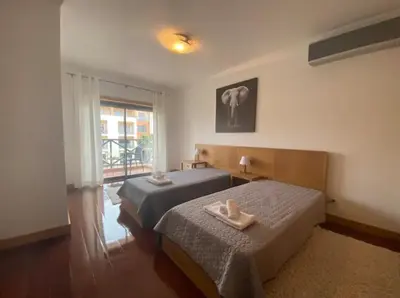 a bedroom with two beds and a window at Casa Maria in Albufeira