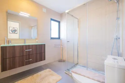 a bathroom with a shower and a toilet and a sink at Villa Aboim - BY BEDZY in Guia