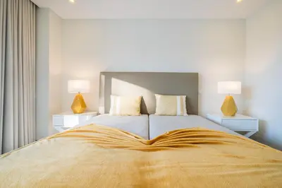 a bedroom with a large bed with two lamps at Villa Aboim - BY BEDZY in Guia