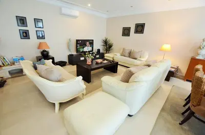 a living room with two white chairs and a table at Suites & Beds DP Albufeira in Albufeira