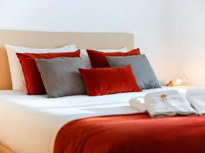 a large bed with red and gray pillows on it at Magnólia AB House by Stay ici Algarve Holiday Rental in Albufeira