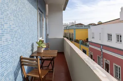 a balcony with two chairs and a table on a building at Faro Guest Apartments in Faro