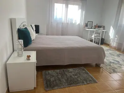 a bedroom with a large bed and a table and a chair at Casa Amar in Loulé