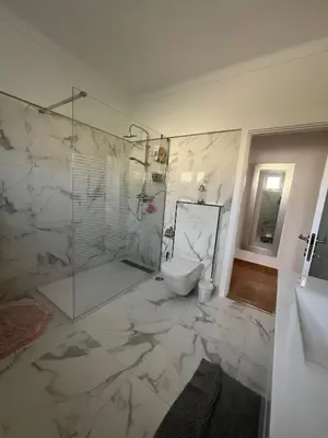 a bathroom with a glass shower and a toilet at Casa Amar in Loulé