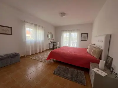a bedroom with a red bed with a red blanket at Casa Amar in Loulé