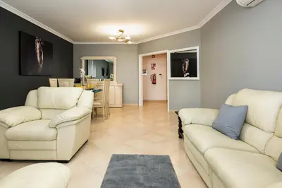 a living room with two couches and a kitchen at Roberto Quarteira Central in Quarteira