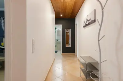 a hallway with white walls and a wooden ceiling at Roberto Quarteira Central in Quarteira