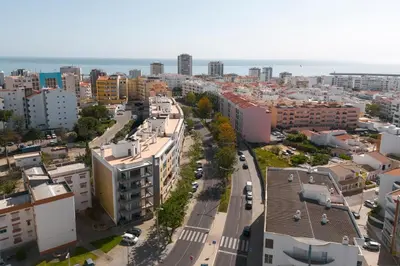 an aerial view of a city with buildings and a street at Roberto Quarteira Central in Quarteira