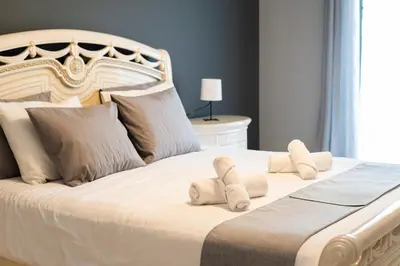 a large white bed with two towels on it at Roberto Quarteira Central in Quarteira