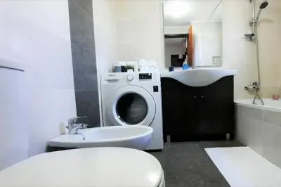 a bathroom with a washing machine and a sink at Excellent 1 Bedroom Villa - em Clube Albufeira Garden Village in Albufeira