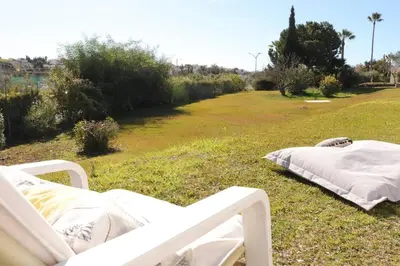 a white bed sitting on the grass in a field at Excellent 1 Bedroom Villa - em Clube Albufeira Garden Village in Albufeira