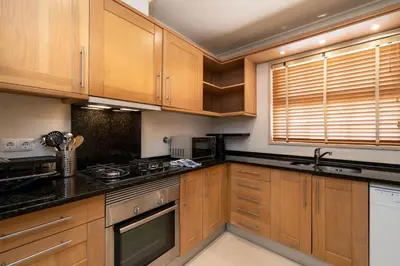 a kitchen with wooden cabinets and a stove top oven at Palmyra by Intiholidays in Vilamoura