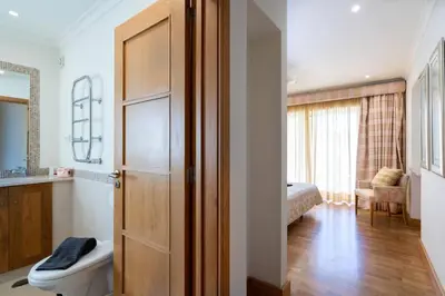 a bathroom with a door to a room with a toilet at Palmyra by Intiholidays in Vilamoura