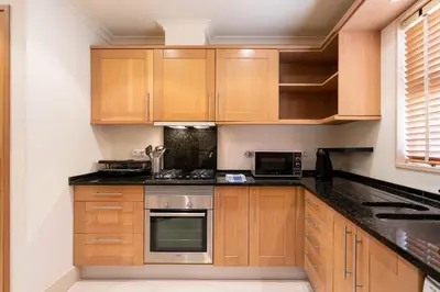 a kitchen with wooden cabinets and black counter tops at Palmyra by Intiholidays in Vilamoura