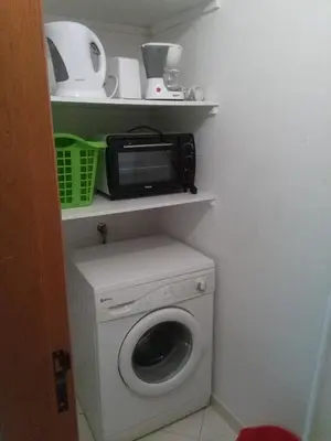 a washing machine with a microwave on top of it at Apartamentos Monica in Quarteira