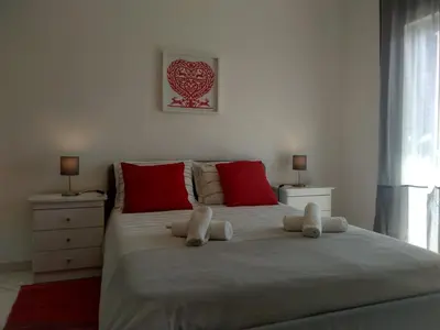 a bedroom with a large bed with red pillows at Apartamentos Monica in Quarteira