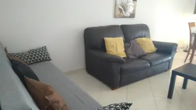 a living room with a gray couch and yellow pillows at Apartamentos Monica in Quarteira