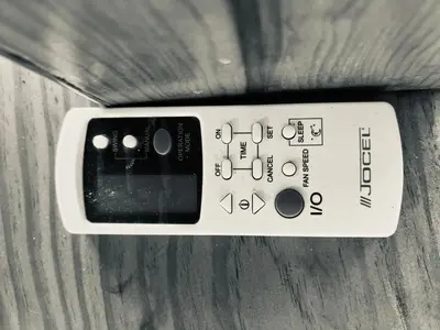 a remote control sitting on top of a wooden table at Point Apartament Praia da Oura in Albufeira