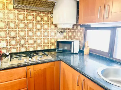 a kitchen with a stove and a sink and a microwave at Point Apartament Praia da Oura in Albufeira