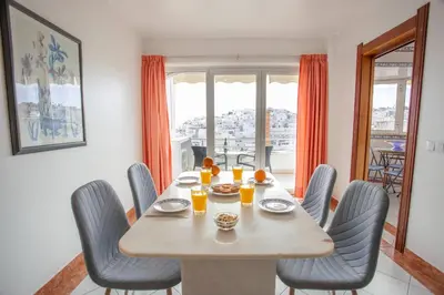 a dining room with a table and chairs and a window at Colibri by HelloVacations in Albufeira