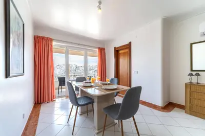a dining room with a table and chairs at Colibri by HelloVacations in Albufeira