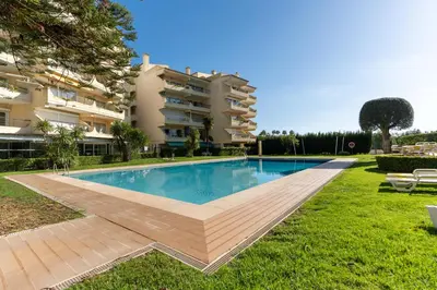 a swimming pool in front of a building at Tasteful 1 BDR Flat W/Balcony & Pool by LovelyStay in Quarteira