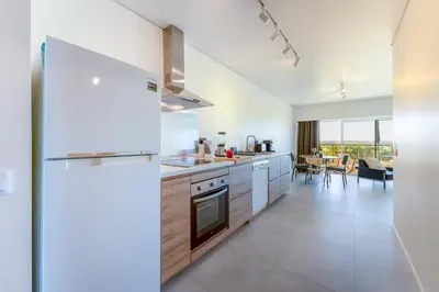 a kitchen with a refrigerator and a dining room at Tasteful 1 BDR Flat W/Balcony & Pool by LovelyStay in Quarteira