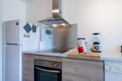 a kitchen with a sink and a refrigerator at Tasteful 1 BDR Flat W/Balcony & Pool by LovelyStay in Quarteira