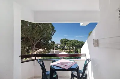 a table and chairs on a balcony with a view at Tenis Golfmar in Vilamoura