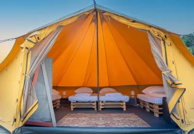 a tent with two beds in it with the door open at Glamping Camp Faro in Faro
