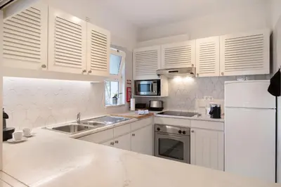 a kitchen with white cabinets and a white refrigerator at Bia in Almancil
