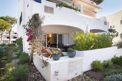 a house with white walls and potted plants at Bia in Almancil