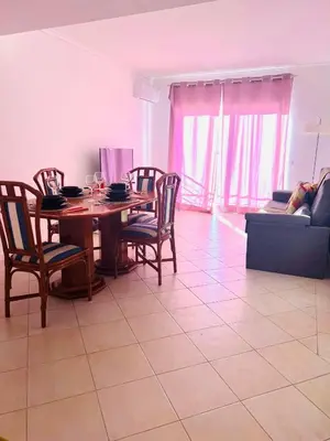 a living room with a table and chairs and a couch at Flat Luxuoso Praia da Oura in Albufeira