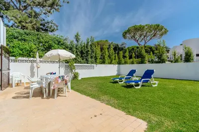 a patio with chairs and a table and an umbrella at Vila Amélia by Sunnyway in Albufeira