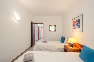 a bedroom with two beds and a table with a lamp at Vila Amélia by Sunnyway in Albufeira