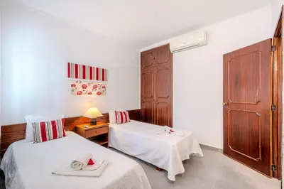 a room with two beds and a table with a lamp at Vila Amélia by Sunnyway in Albufeira