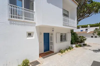 a white house with a blue door at Villa Leeroy in Almancil