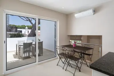 a kitchen with white cabinets and a black counter top at Villa Leeroy in Almancil