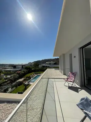 a balcony with a chair and a view of a building at Casa Papoila in Albufeira