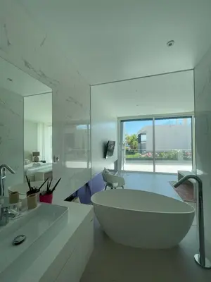 a white bathroom with a tub and a sink at Casa Papoila in Albufeira