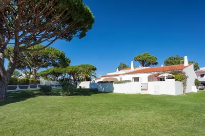 a living room with white furniture and a red rug at Villa Rosa in Vale do Lobo