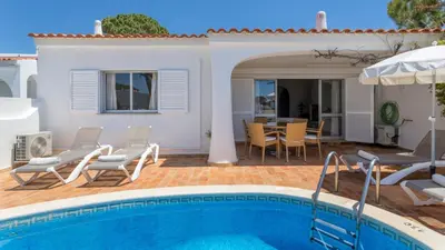 a white bedroom with a bed and a window at Villa Rosa in Vale do Lobo