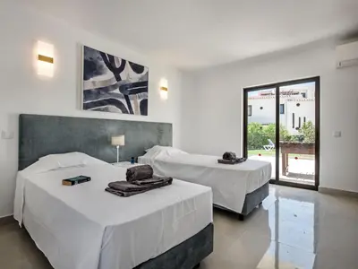 two beds in a white room with a window at Villa Corcovada V4 VIP Properties by Interhome in Albufeira