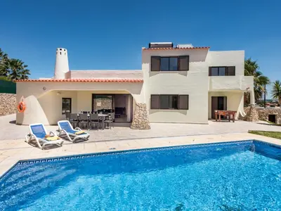 a villa with a swimming pool in front of a house at Villa Corcovada V4 VIP Properties by Interhome in Albufeira