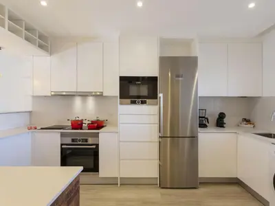 a kitchen with white cabinets and a stainless steel refrigerator at Holiday Home Pierre by Interhome in Galé