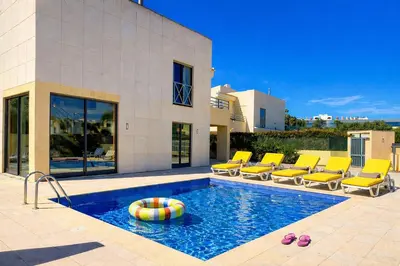 a swimming pool in front of a house at Villa Paula with Private Pool Close to the Beach and Strip in Albufeira