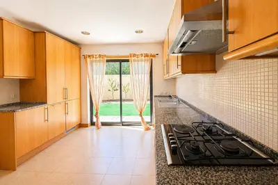 a kitchen with wooden cabinets and a sink at Villa Paula with Private Pool Close to the Beach and Strip in Albufeira