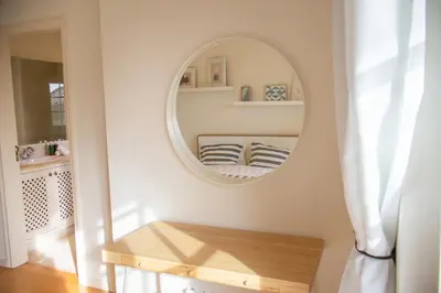 a mirror on a wall in a room with a bench at Quinta do Lago Golfside Retreat in Quinta do Lago