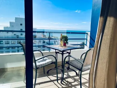 a table on a balcony with a view of the ocean at Pérola do Algarve in Quarteira